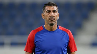 Middle-aged male coach, athletic build, mid-40s, waist-up, intense expression, short dark hair, slight stubble, eyes...