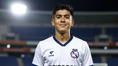 A photorealistic image of a young Mexican U-20 player with a determined expression, wearing a Puebla jersey with a white...