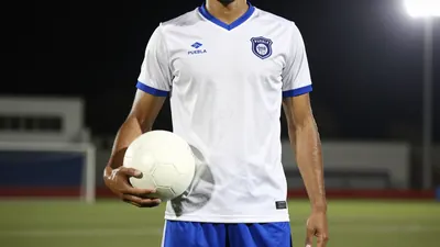 A photorealistic image of an anonymous Puebla player in their white jersey with a blue stripe, wearing a blue pair of...