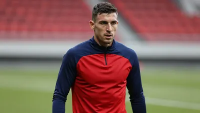 Mid-30s muscular forward, waist-up, intense gaze, face fully visible, wearing a plain blue and red training top (solid...