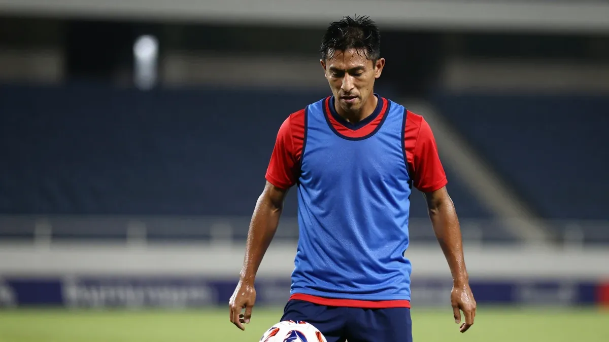 A tight, waist-up shot of a rugged, 30-year-old Puebla midfielder, dressed in a plain, blue and red, cotton training top...