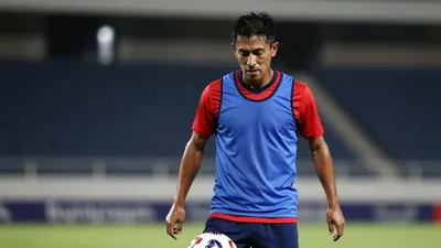 A tight, waist-up shot of a rugged, 30-year-old Puebla midfielder, dressed in a plain, blue and red, cotton training top...