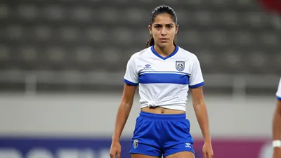 A tight waist-up action crop of a young, anonymous, 22-year-old female Puebla player in a white jersey with a blue...